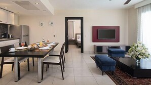 A modern kitchen with a dining area, a living room with a TV, and a view into the bedroom. - Cofresi Puerto Plata Dominican Republic  (Puerto Plata)