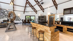 A modern kitchen with a wooden island, bar stools, and a large decorative piece.