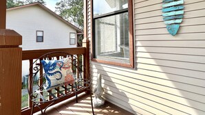 Un portico con ringhiera metallica, un cuscino decorativo e un ornamento a parete.