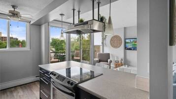 A modern kitchen with a large island, built-in oven, and pendant lighting.