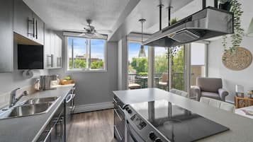 A modern kitchen with a large stove, stainless steel appliances, and a view of the outdoors.