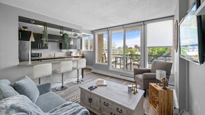 Un apartamento moderno con cocina, comedor y sala de estar. Cuenta con ventanas amplias, un balcón y vistas a la ciudad.