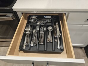 Eine Schublade mit einem Besteckeinsatz, der Gabeln, Löffel und ein Messer enthält.