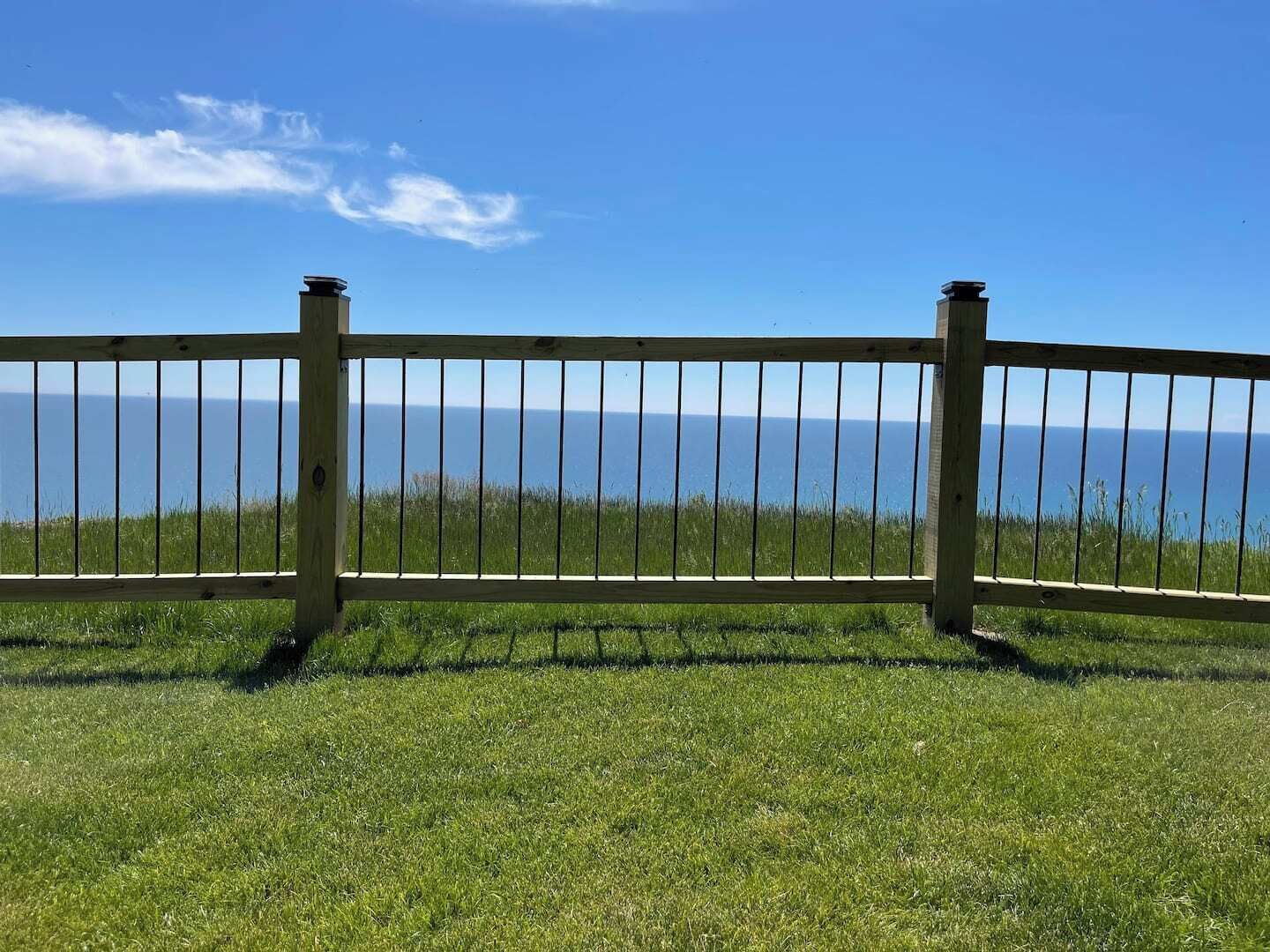 Une clôture en bois offrant une vue sur l’océan.