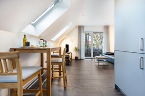 Een moderne keuken met dakraam, houten eettafel en stoelen.