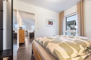 Une chambre d’hôtel moderne avec un grand lit, un bureau et une vue sur un bâtiment situé à l’extérieur.