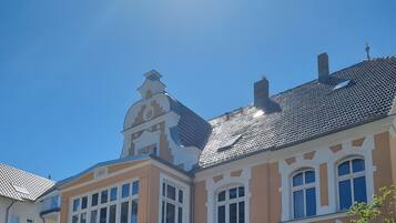 Ein Gebäude mit einem Schild 'Villa Adler' und einem Balkon mit einem Korbwäscheschrank.