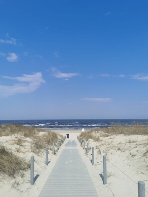 A wooden boardwalk leading to a beach with sand dunes and a clear blue sky. - Apartment "Villa Adler - Seeblick" with Lake View (Seebad Ahlbeck)