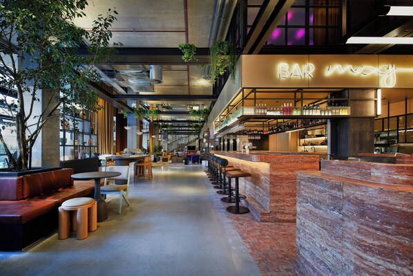 Un área de bar moderna con asientos y un letrero de neón.