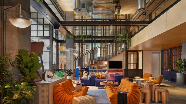 A modern interior with a central seating area, a staircase, and a large window. - Moxy Sydney Airport (Mascot)