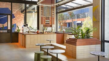 A modern cafe with a brick wall, large windows, and a menu board.