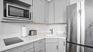 Eine moderne Küche mit einem Edelstahl-Kühlschrank, einer Mikrowelle, einem Toaster und einem Spülbecken.