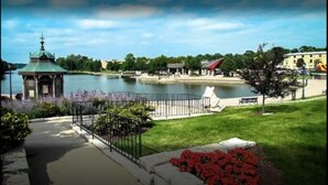 Un parc au bord du lac, doté d’un kiosque, d’une aire de jeux et d’un bâtiment au toit rouge.