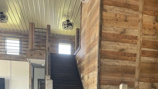 Eine Holztreppe mit Metallgeländern, die zu einer höheren Etage führt.