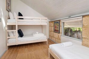 A bunk bed room with a window and a poster on the wall.