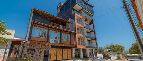 A multi-story building with a stone facade, a balcony, and a sign that reads "Casa Creations."
