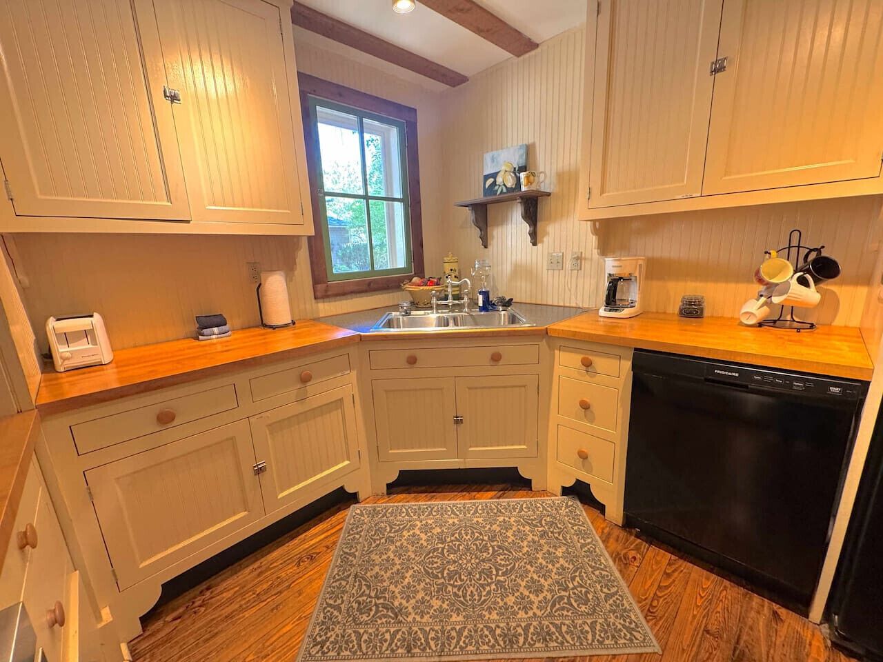 A kitchen with wooden cabinets, a dishwasher, and a window.