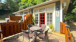 A small building with a red door, a sign reading 'Studio A,' and a patio with a table and chairs. - 66 Center - The Studio (Eureka Springs)