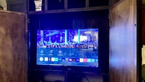 A television displaying a news channel interface with multiple news channels and a 'Breaking and Latest News' banner. - 66 Center - The Studio (Eureka Springs)