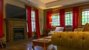 Una sala de estar con chimenea, televisor y sofá.