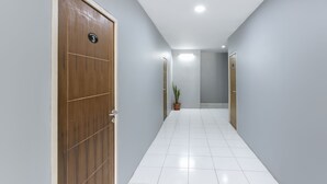 A hallway with a wooden door marked "3", a potted plant, and a tiled floor. - Collection O 3130 D'Valley View (Lembang)