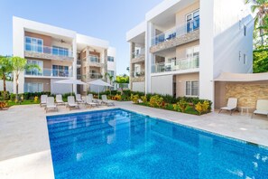 Un hôtel moderne doté d’une piscine, de nombreux balcons et d’espaces extérieurs aménagés pour se détendre.
