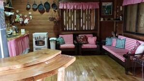 Une cuisine chaleureuse avec un plan de travail en bois, un réfrigérateur, une cuisinière et un canapé à carreaux.