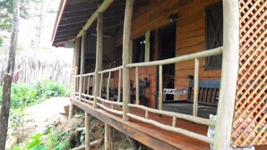 Un bâtiment en bois doté d’un porche et d’une clôture en bois.