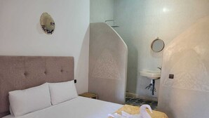 A hotel room with a bed, a bathroom with a shower, and a sink. - RIAD MALAYINE (Marrakech)