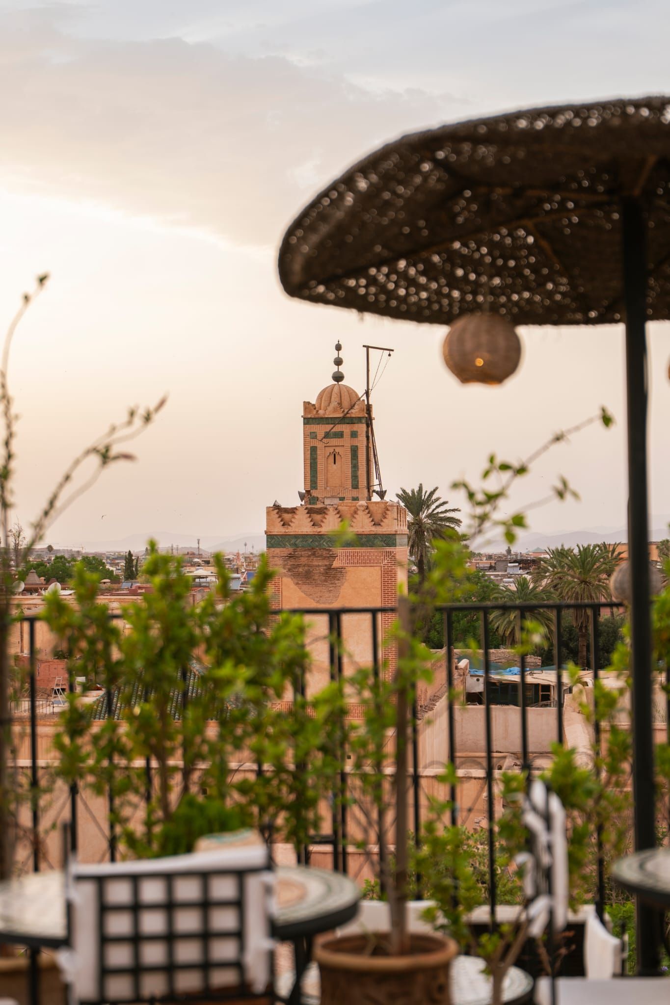 A terrace with a view of a tower, potted plants, and outdoor furniture.