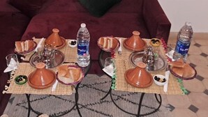 A dining setup with traditional Moroccan tableware, including tagines and teapots, on a woven mat. - RIAD MALAYINE (Marrakech)