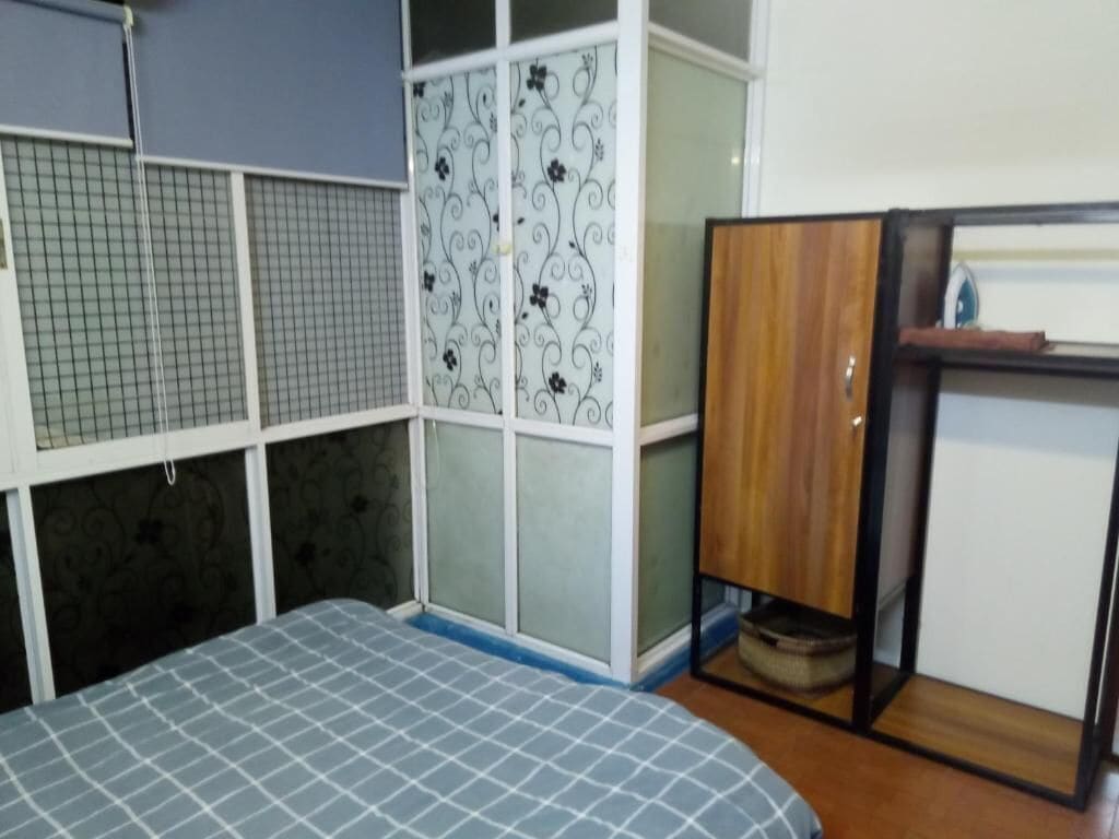 A room with a bed, a wardrobe, and a small table.