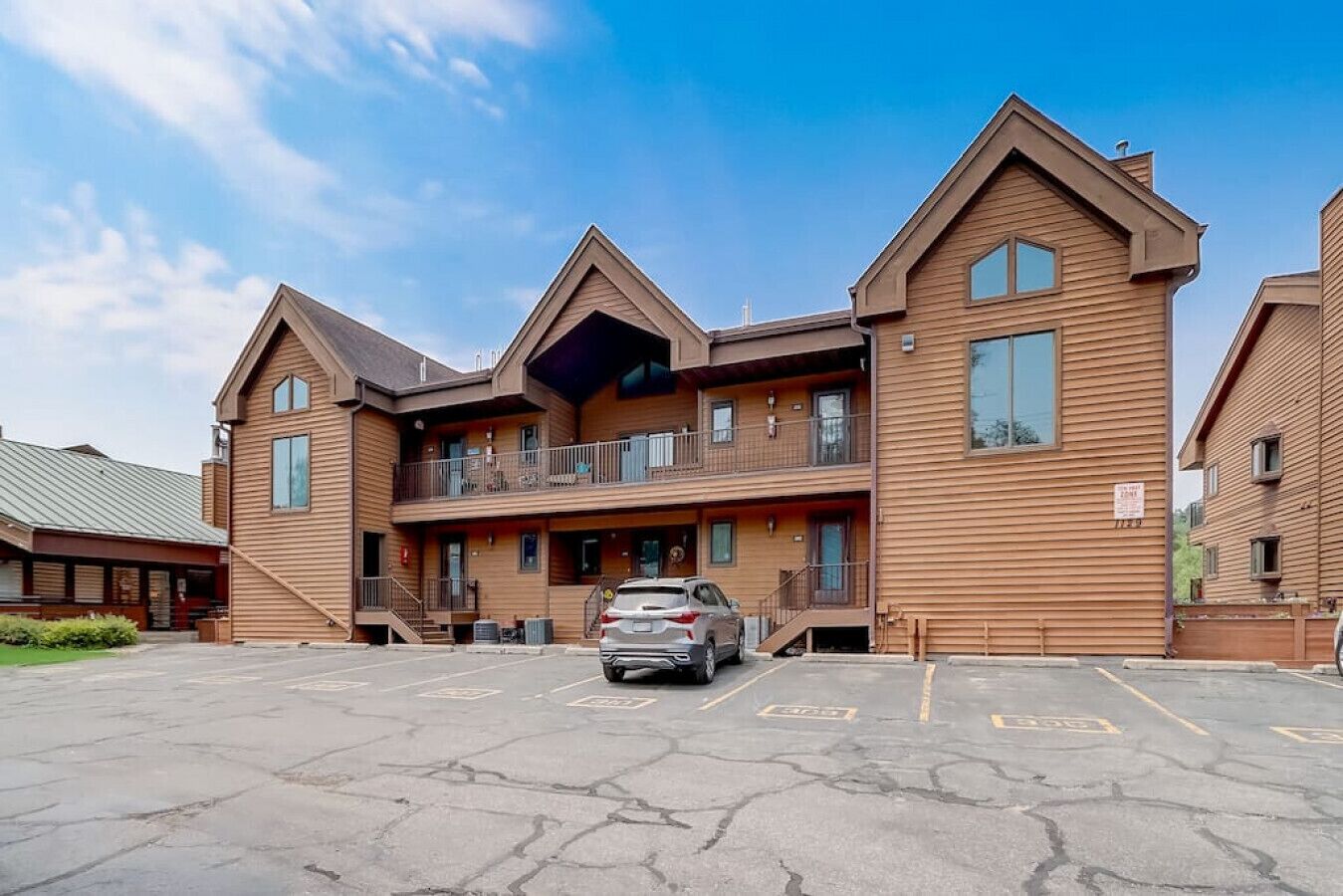A multi-story hotel with a parking lot in front.