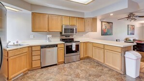 A modern kitchen with wooden cabinets, stainless steel appliances, and a large island. - Josie's On The Bay - Waterfront, Fireplace, Roku (Wisconsin Dells)