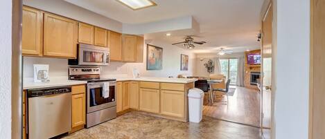 A kitchen with wooden cabinets, a microwave, an oven, and a dishwasher.