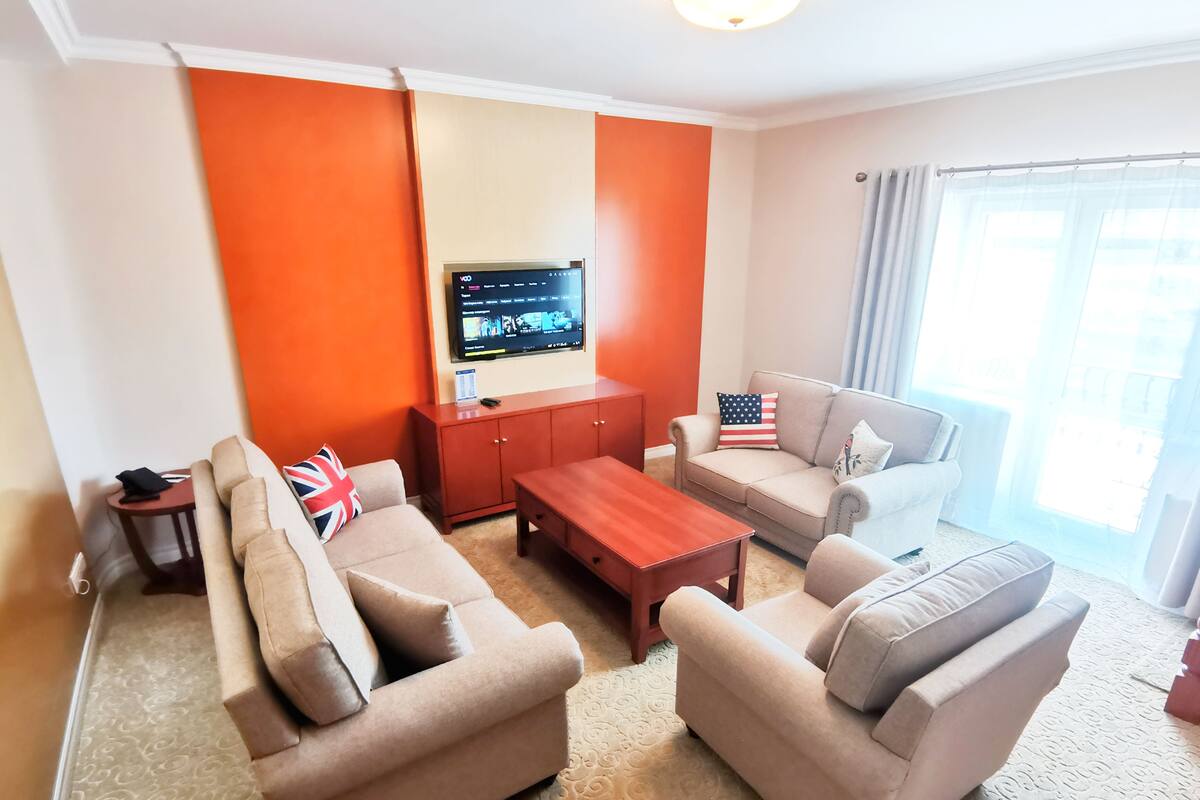 Ein Wohnzimmer mit zwei Sofas, einem Couchtisch, einem Fernseher und einem Schrank.