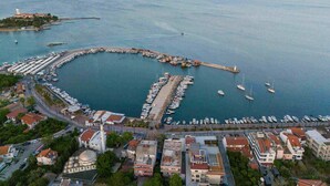 An aerial view of a coastal town with a marina, boats, and a prominent mosque. - Ma-Si Urla Hotel (Urla)