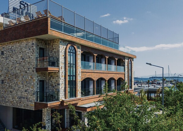 A modern building with a stone facade, multiple balconies, and large windows. - Ma-Si Urla Hotel (Urla)
