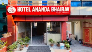 The exterior of Hotel Ananda Bhairav with a red signboard, potted plants, and a gated entrance. - MeroStay 107 Hotel Bhairav Ananda  (Kathmandu)