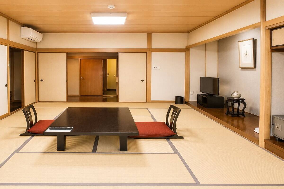 A traditional Japanese-style room with tatami flooring, a low table, and sliding doors.