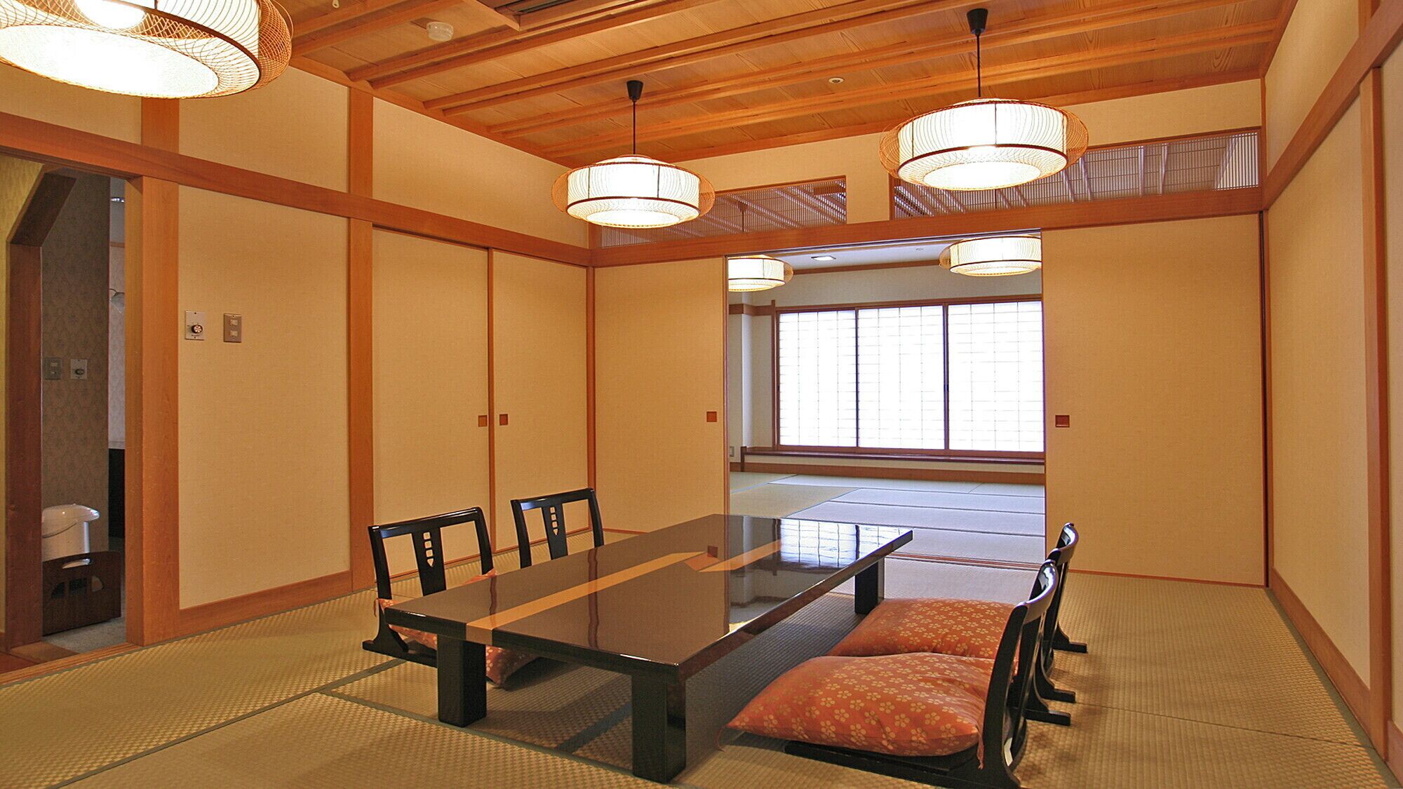 A traditional Japanese room with tatami flooring, a low table, and wooden sliding doors.