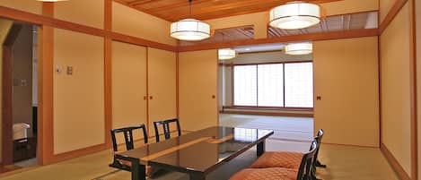 A traditional Japanese room with tatami flooring, a low table, and wooden sliding doors.