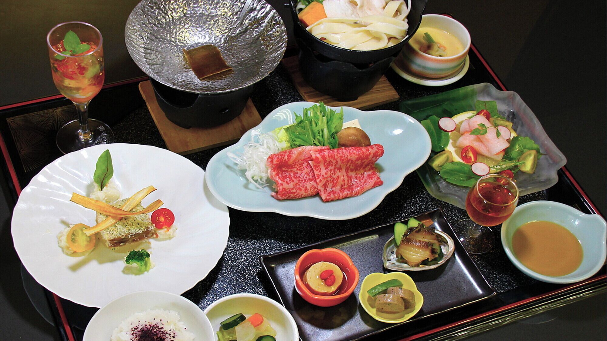 Una bandeja con diversos platos, incluyendo sushi, sashimi y una cazuela de sopa.
