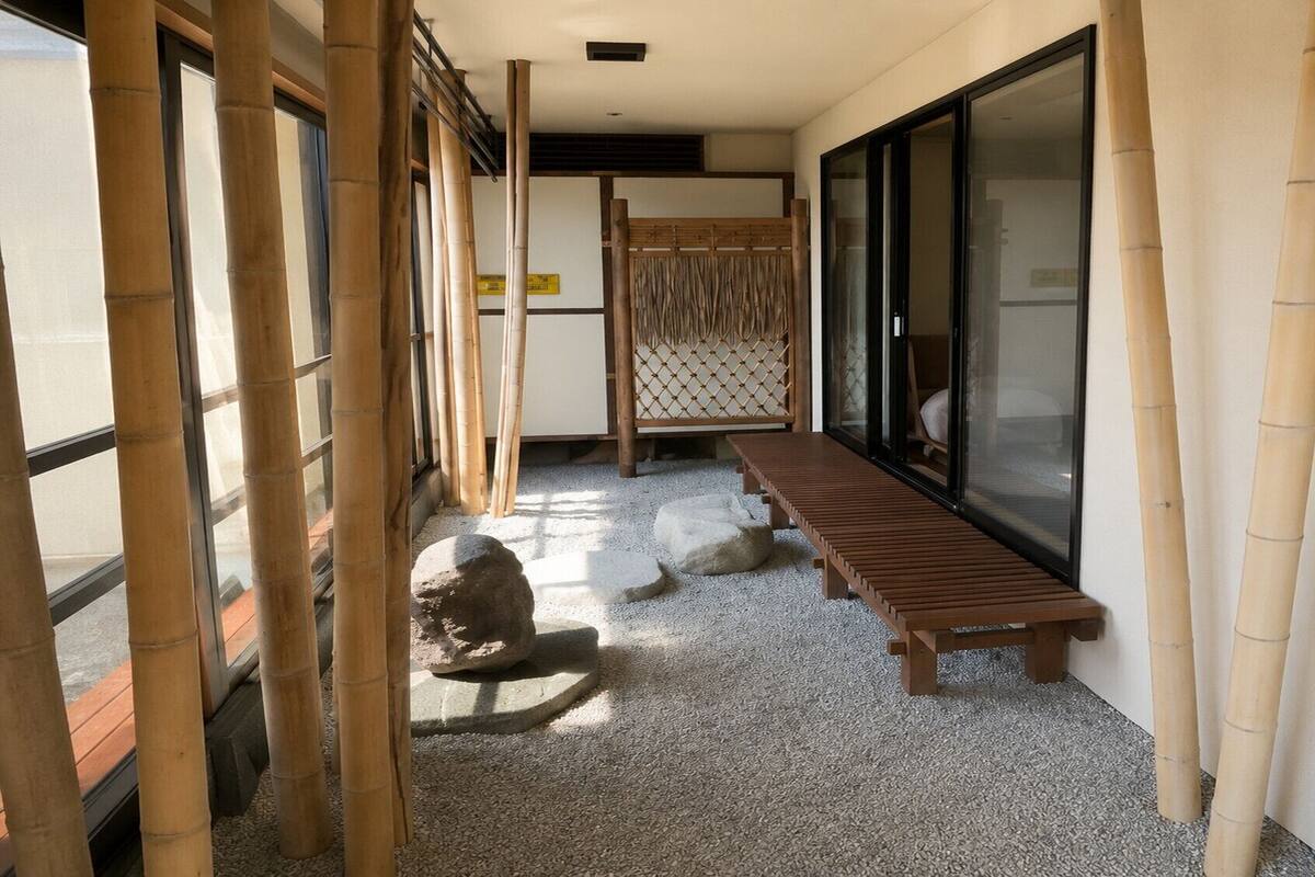 A corridor with a wooden bench, bamboo pillars, and a tatami mat area.