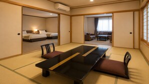 A traditional Japanese-style room with tatami flooring, a low table, and a sofa. - LiVEMAX RESORT Isawa Onsen (Fuefuki)