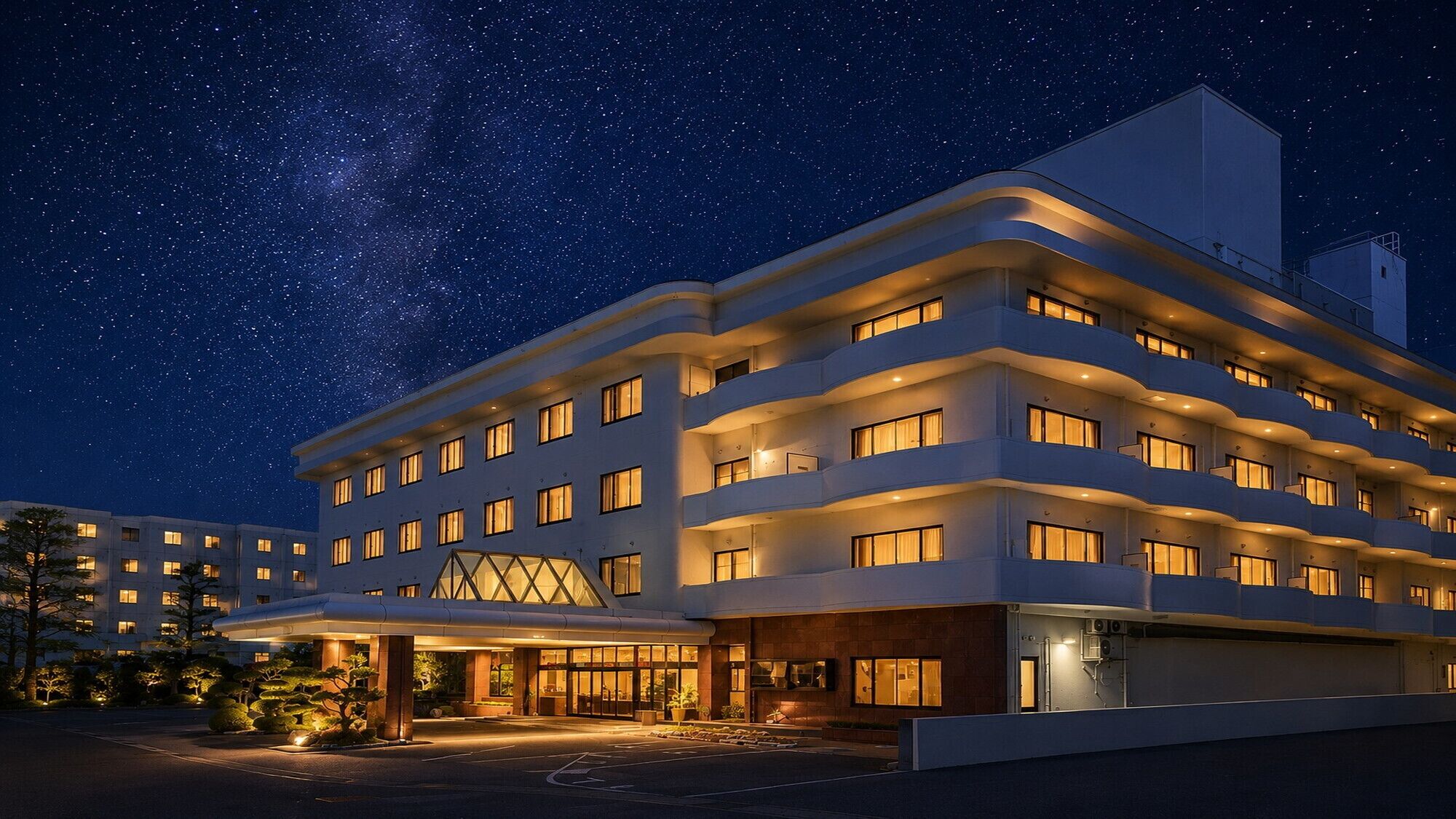 A multi-story hotel with a modern design, featuring a prominent entrance and multiple balconies.