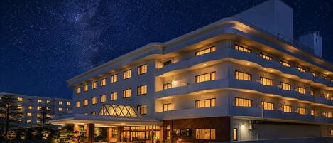 A multi-story hotel with a modern design, featuring a prominent entrance and multiple balconies.