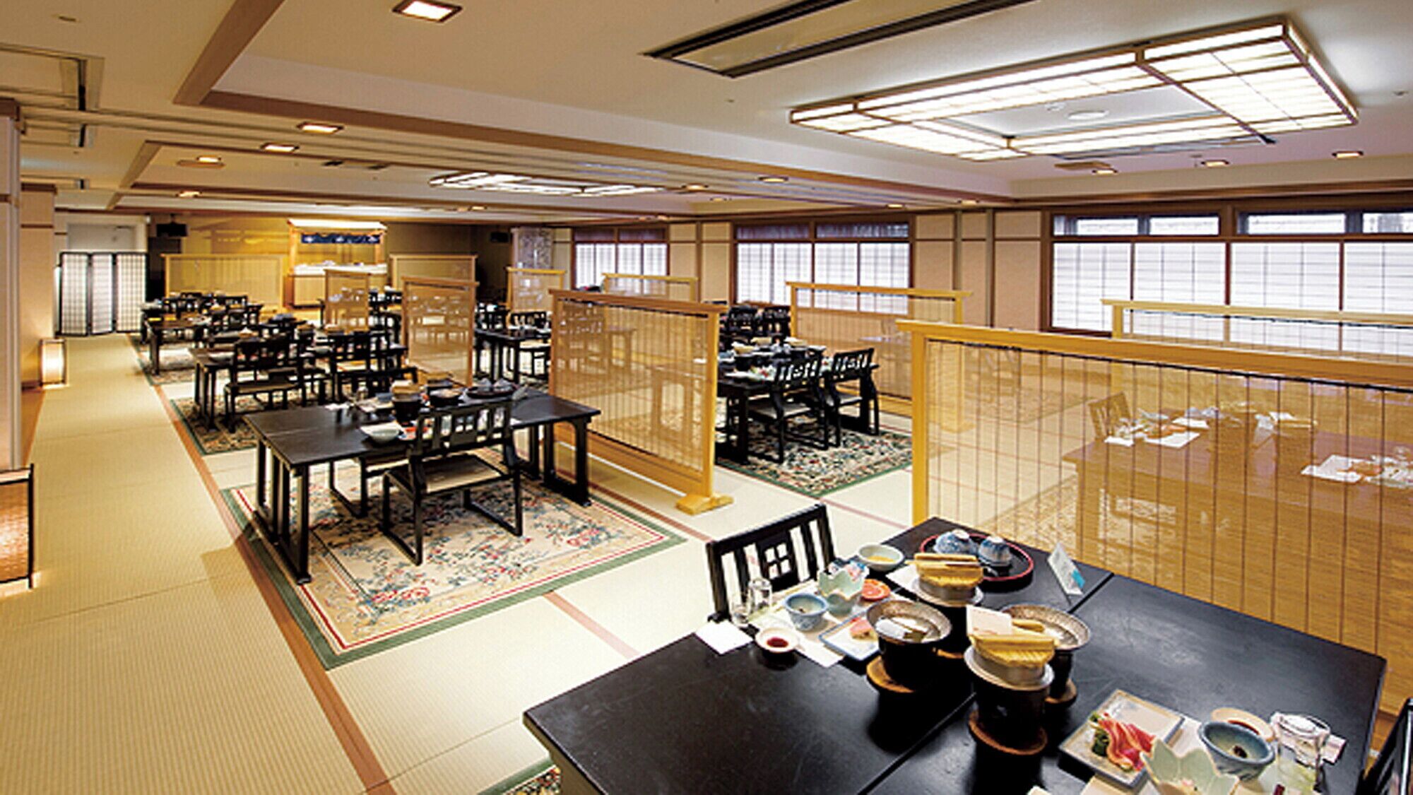 En traditionell japansk restaurang med tatamimattor på golvet, låga bord och skjutdörrar.