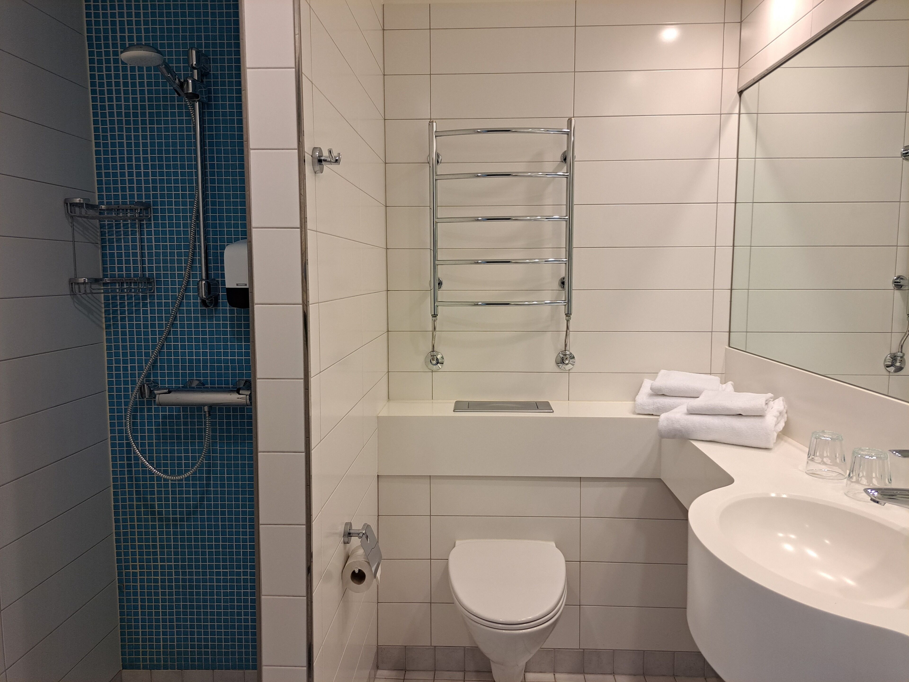 Un baño moderno con ducha, inodoro y lavamanos.