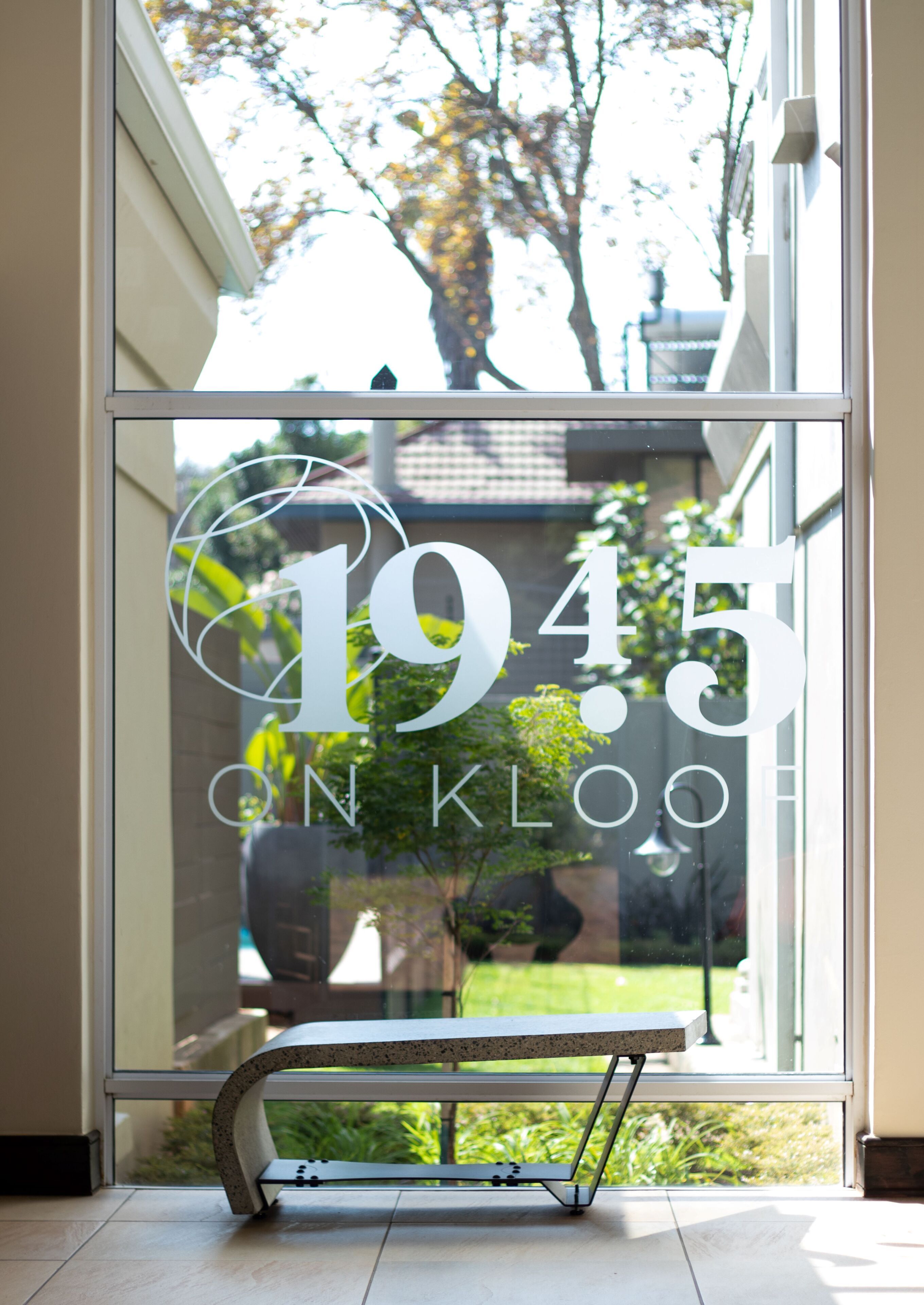 A glass door with the number "1945" and the words "ON KLOOF" etched into it.